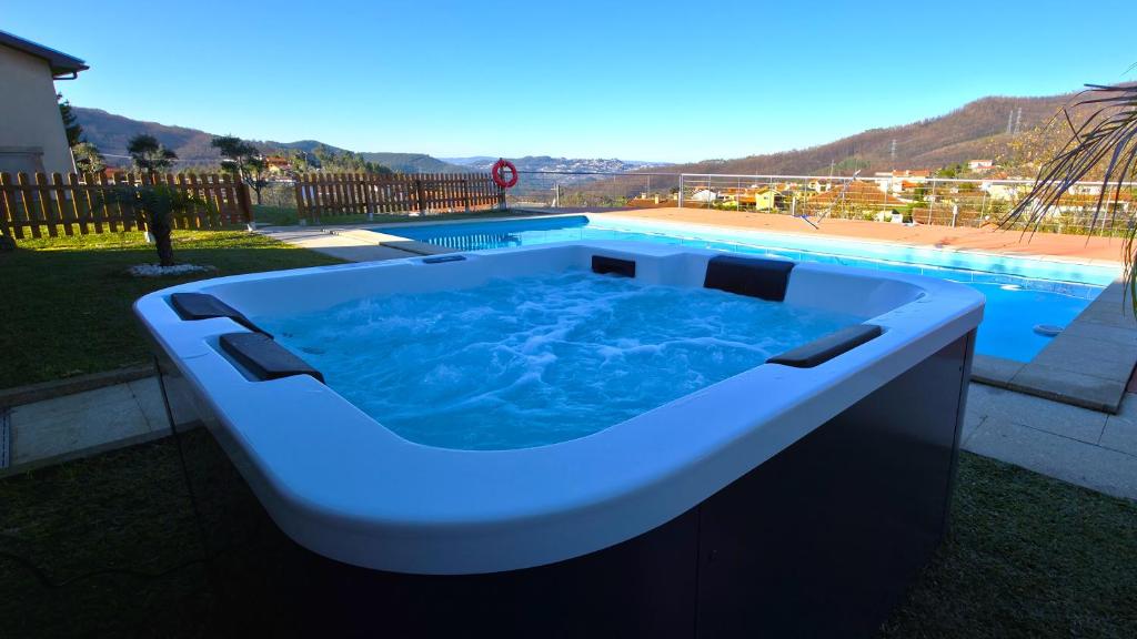 eine große Badewanne neben einem Pool in der Unterkunft Martins House in Vila Viçosa