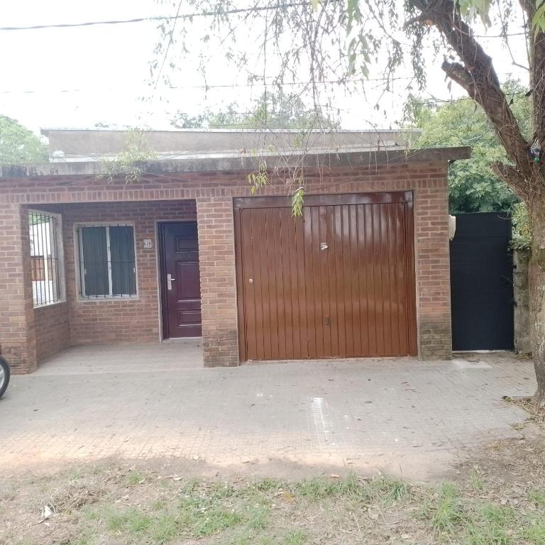 a brick house with a garage with a door at La Olimareña in Treinta y Tres