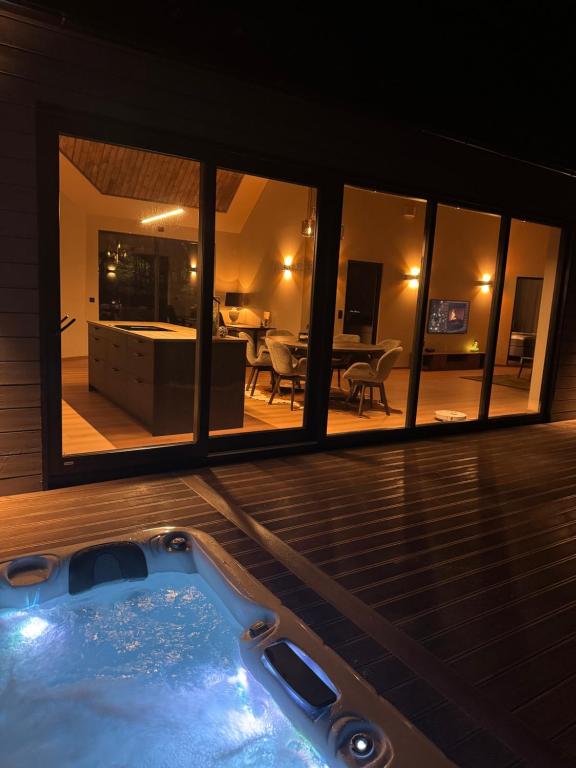 une baignoire jacuzzi dans une maison avec salon dans l'établissement LyNora Lodge, 