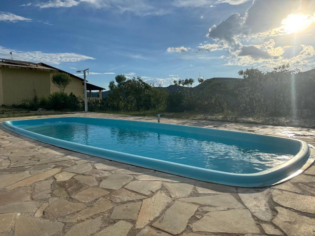 einen Pool inmitten einer Steinterrasse in der Unterkunft Sítio Vista da Serra - Carrancas in Carrancas