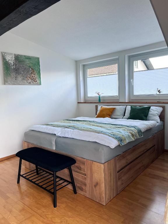 a large bed in a room with two windows at Ferienwohnung Wolfsgarten in Rauschenberg