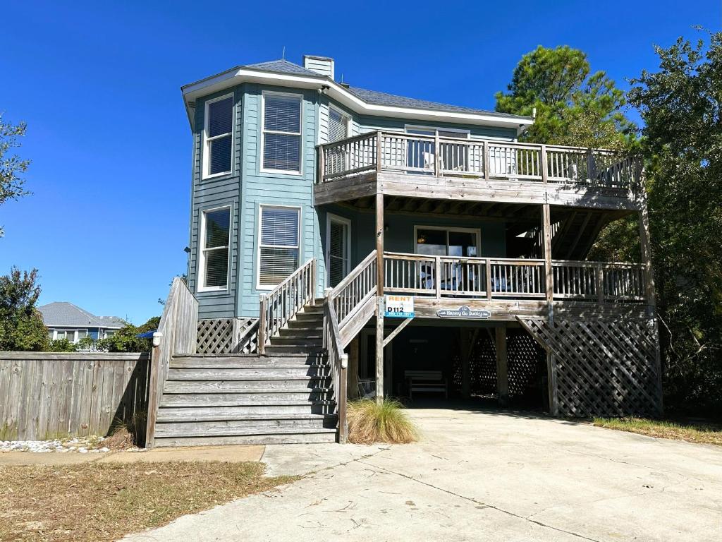 a large blue house with a deck and stairs at D112-Happy Go Ducky in Duck