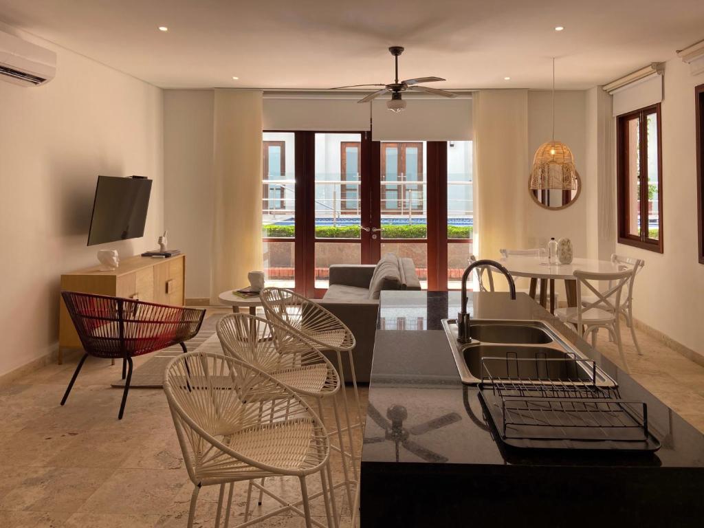 een keuken en een woonkamer met stoelen en een tafel bij Virrey Luxury Aparments in Ciudad Amurallada in Cartagena