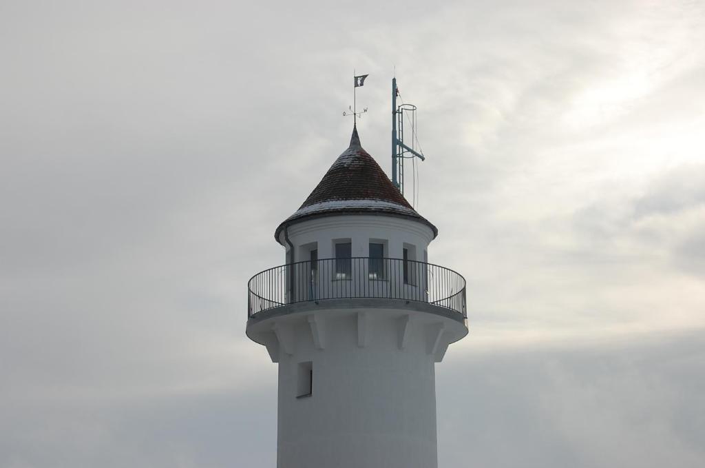 un faro bianco con una torre con un tetto di Lotsenturm Usedom a Karnin