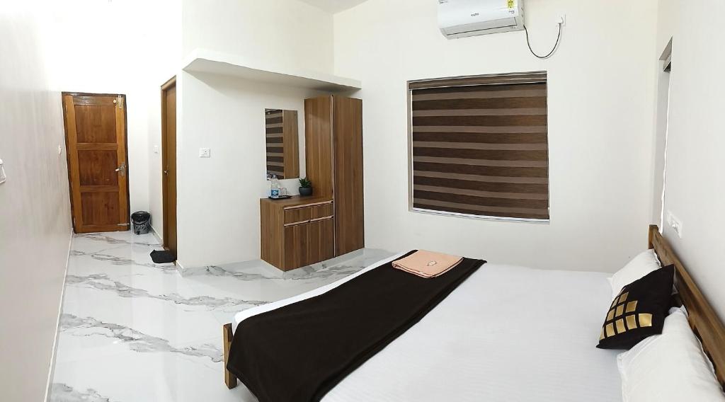 ein weißes Zimmer mit einem Bett und einem Fenster in der Unterkunft Sandora Home Stay in Varkala