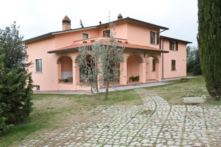 a large pink house with a stone path in front of it at Agriturismo Le 3 Rose in Antria