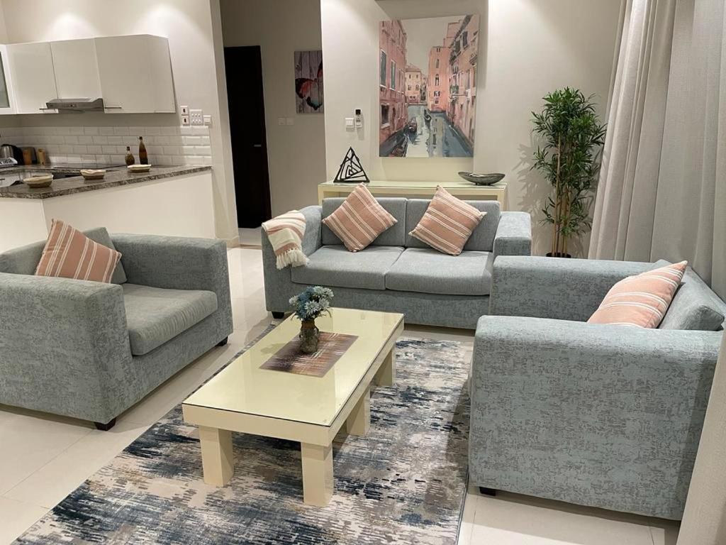 een woonkamer met twee banken en een salontafel bij منتجع هوانا غرفتين in Salalah