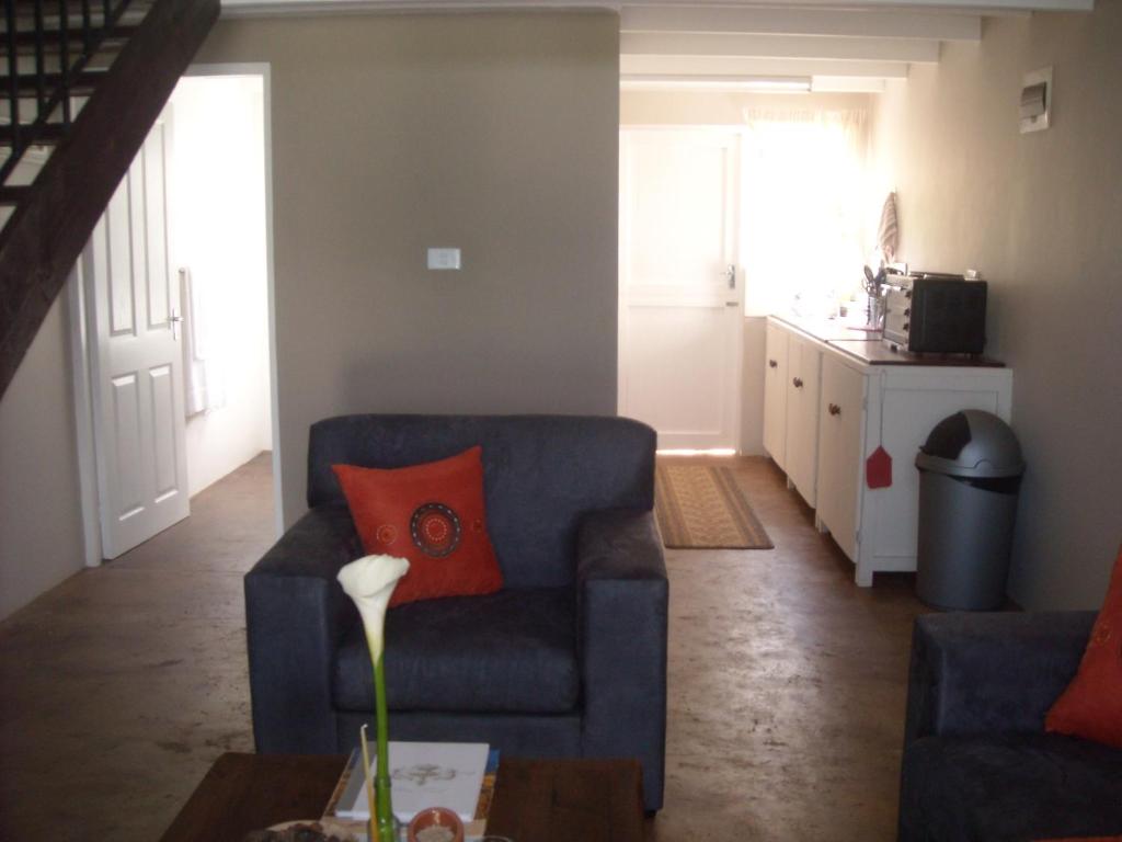 a living room with a blue couch and a table at Enniskerry Self-Catering in Lidgetton