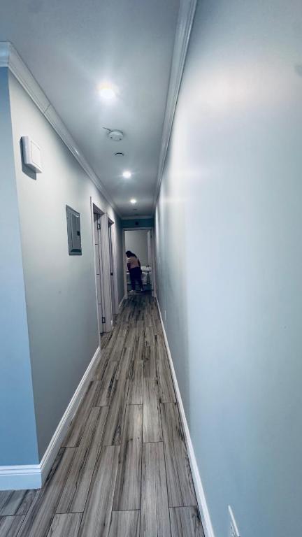 a hallway with blue walls and a wooden floor at Explore Rooms JFK in Locust Manor