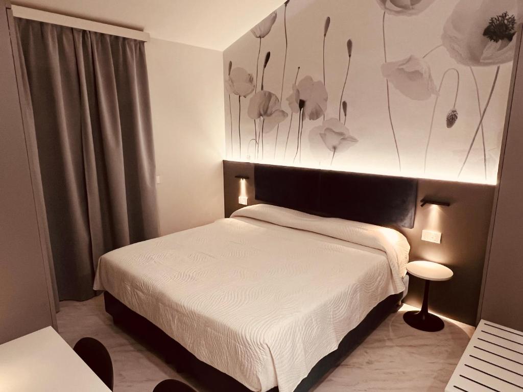 een slaapkamer met een bed en een muur met bloemen bij Del Prado in Riva Ligure