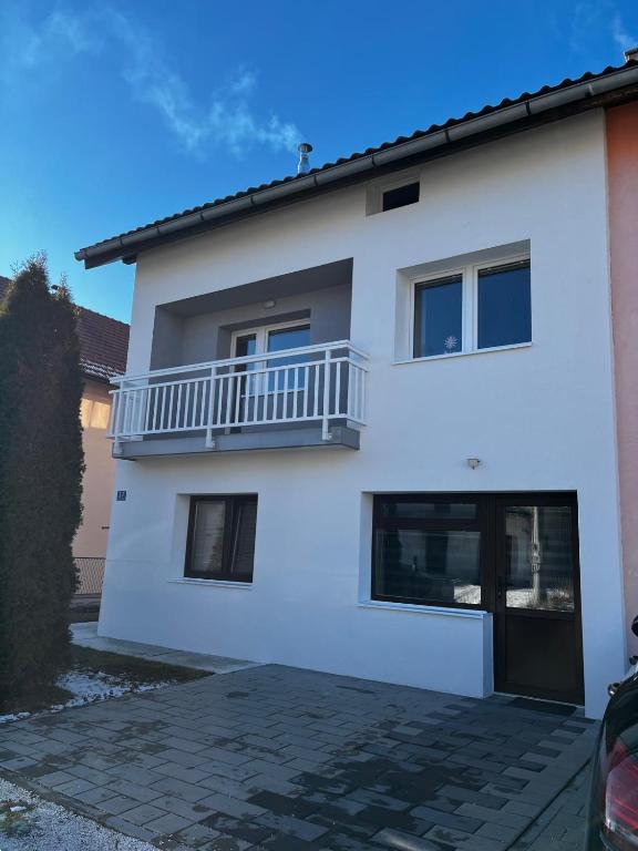 een wit huis met een balkon bij Apartman Marija in Kupres