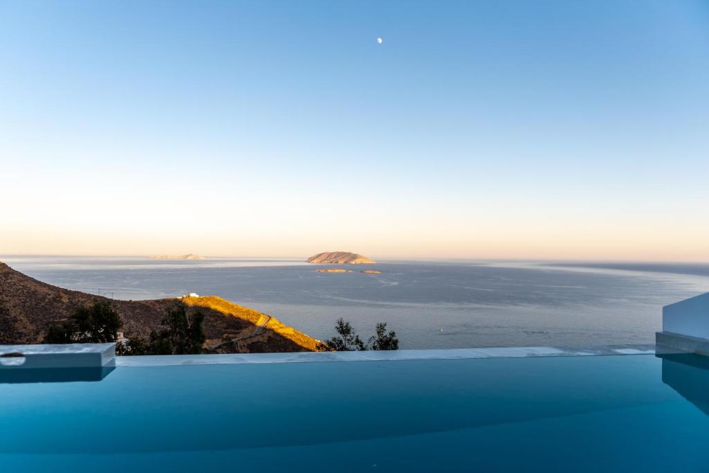 a swimming pool with a view of the ocean at Althea Anafi Suites in Anafi