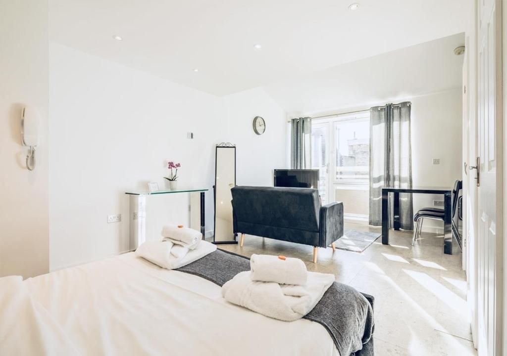 a white bedroom with a large bed with towels on it at Riverlight Studio sleep 3 in Cambridge