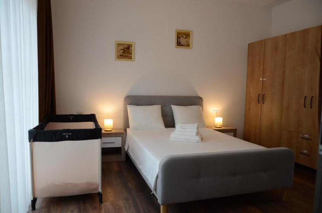 een slaapkamer met een wit bed en 2 lampen bij Vila Bella in Oradea