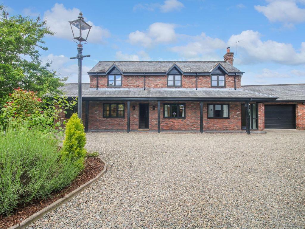 a brick house with a driveway in front of it at 1 Clarkes Lane in Oswestry