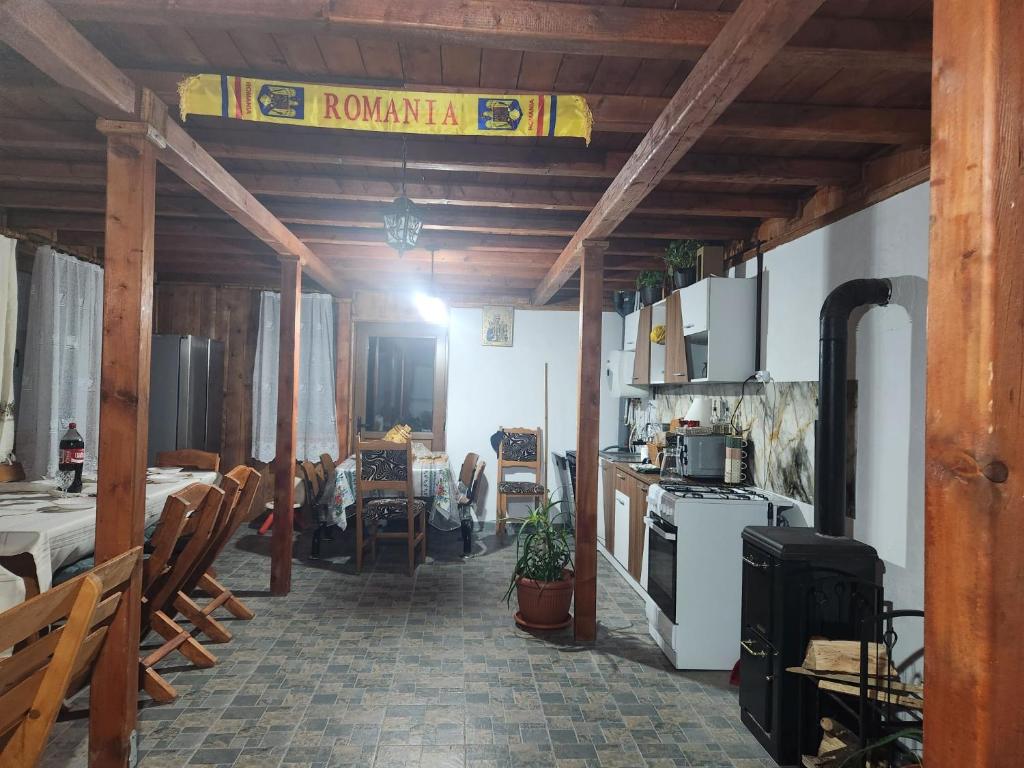 a kitchen with a stove and a table and chairs at Cabana Maria in Olăreşti