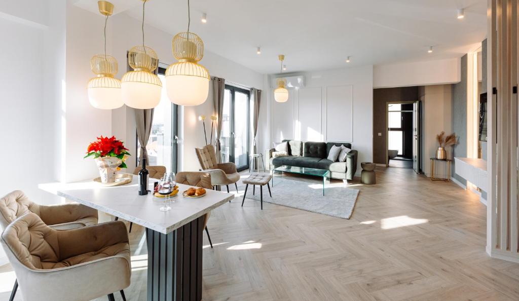 ein Wohnzimmer mit Tisch und Stühlen in der Unterkunft Luma Central Viewpoint with Private Underground Parking in Târgu Mureș