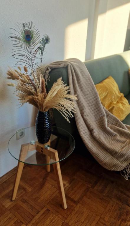 a vase with a plant on a glass table at Cozy and fully equipped flat in the centrum in Essen