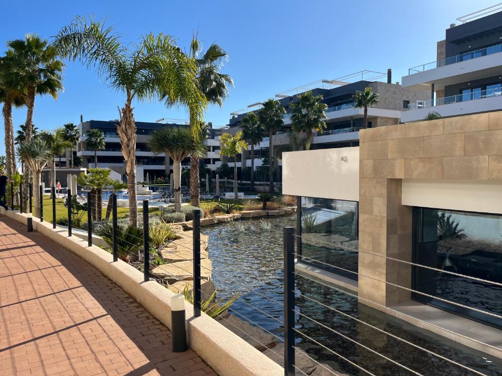 a river with palm trees in front of a building at Flamenca Village- Apartment 459 in Orihuela Costa