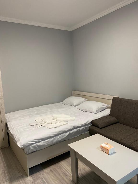 een slaapkamer met een bed, een bank en een tafel bij Elite guest house in Pʼarakʼar