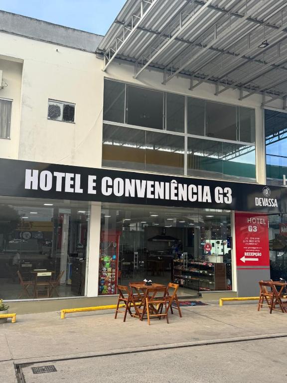 a group of tables and chairs in front of a building at Hotel e Conveniência G3 in Teixeira de Freitas