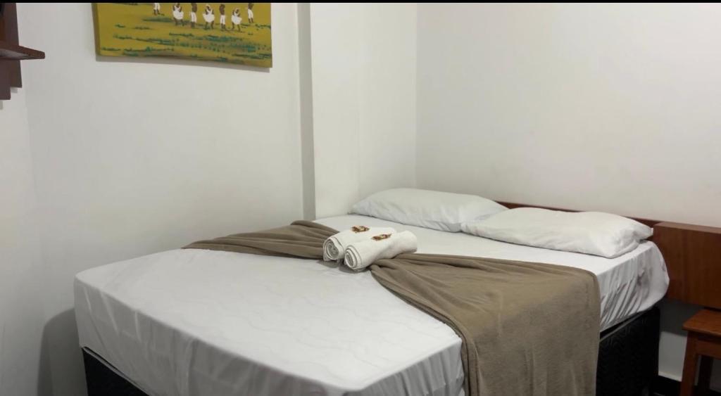 una camera da letto con due letti con asciugamani sopra di Hotel e Conveniência G3 a Teixeira de Freitas