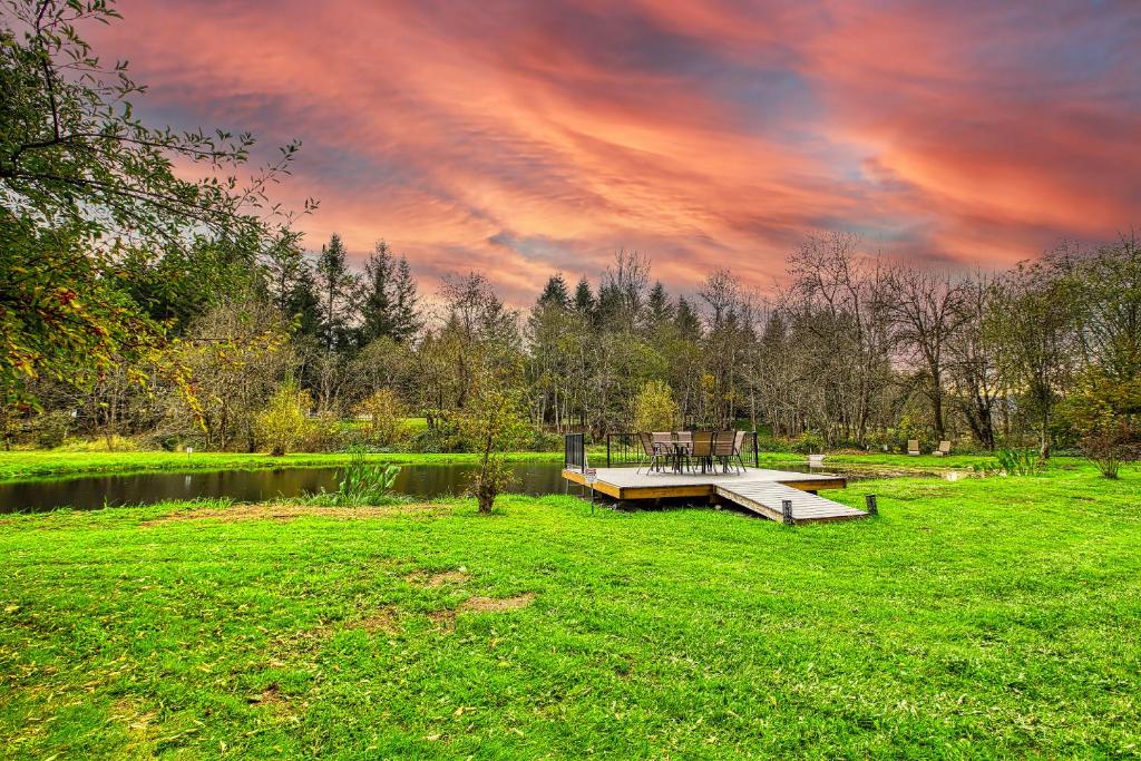 a picnic table on a dock in a field with a lake at 4-Bedroom Chateau in Southern Washington- Luxurious Retreat with Pond & Creek in Amboy