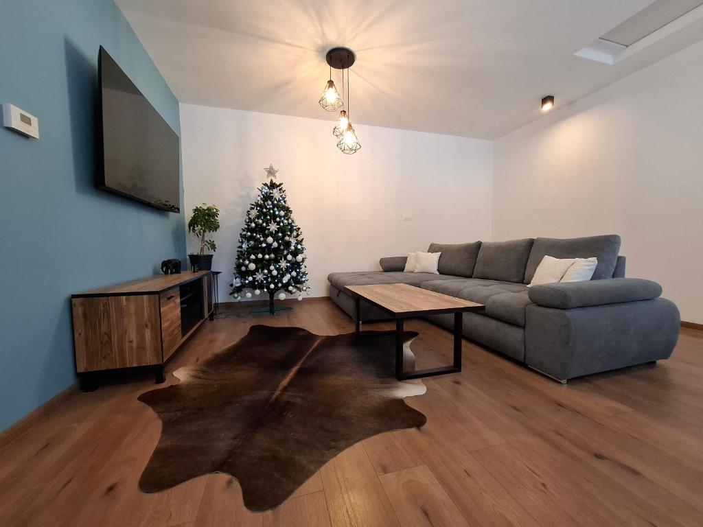 een woonkamer met een bank en een kerstboom bij Chata pod vŕškami Važca in Važec
