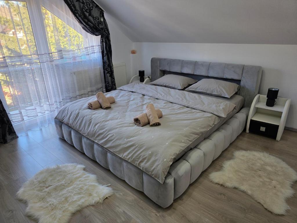 een slaapkamer met een groot bed met twee teddyberen erop bij Mountain View Apartment in Zărneşti