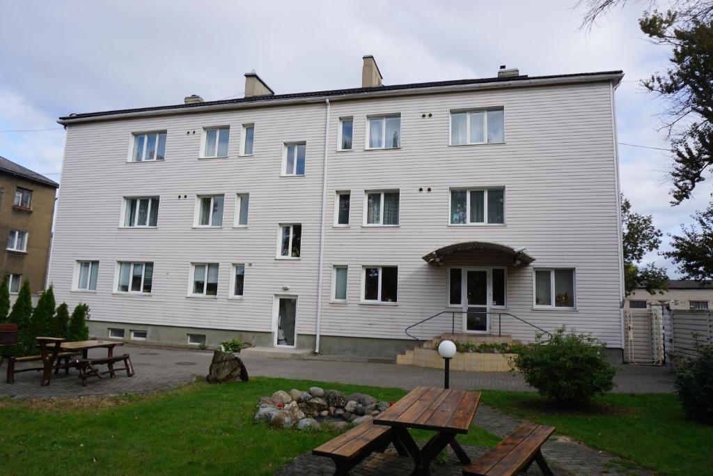 un gran edificio blanco con una mesa de picnic delante de él en Duets en Daugavpils