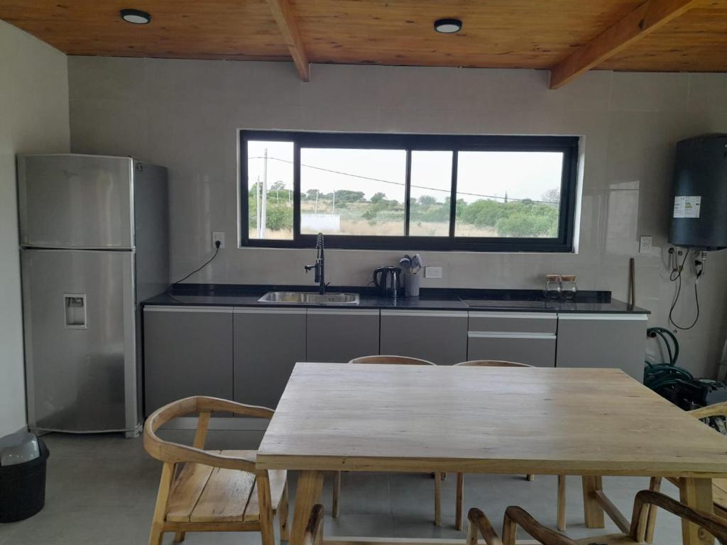 a kitchen with a table and a sink and a refrigerator at Casa Aramí in Victoria