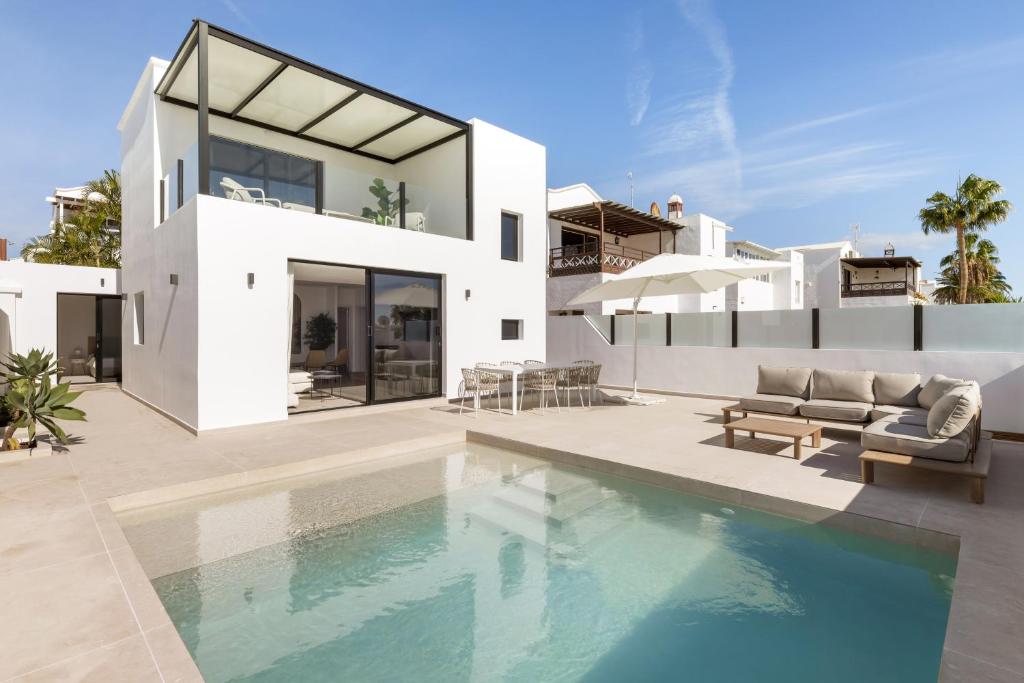 a house with a swimming pool in front of a house at Villa Sara-Princesa Ico in Tías