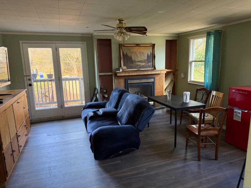 een woonkamer met een bank en een tafel bij A fully self-contained one-bedroom apartment in Fredericton