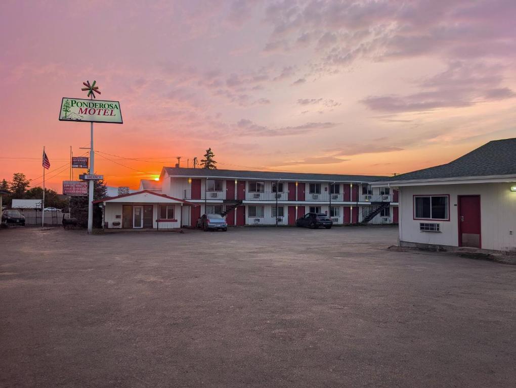 een motelbord op een parkeerplaats voor een motel bij Ponderosa Motel in Goldendale