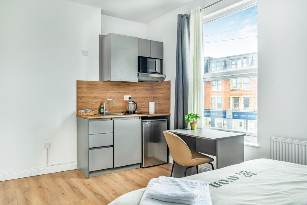- une cuisine avec un évier et un bureau dans la chambre dans l'établissement Modern Studios near Trent Bridge & City Ground, à Nottingham