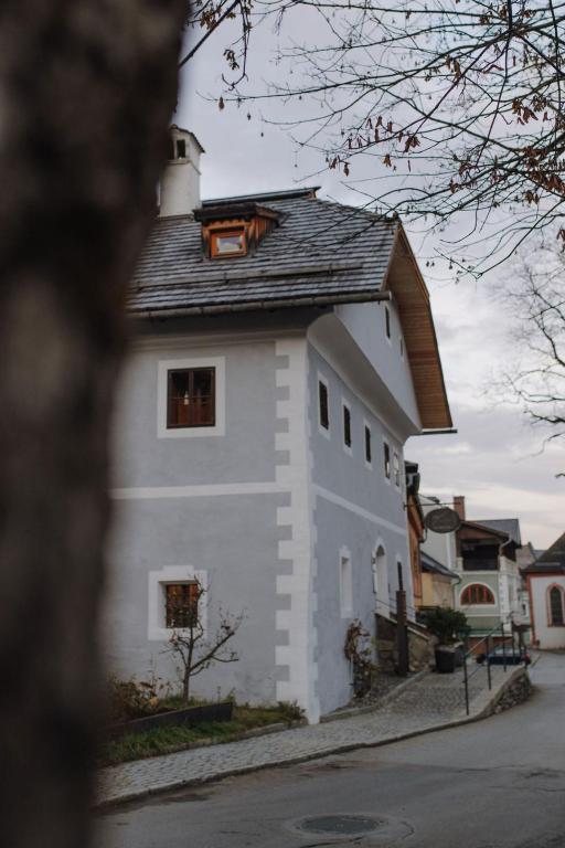 a white building with a black roof at Mesnerhaus & Gourmetrestaurant Mesnerhaus mit 4 Hauben in Mauterndorf