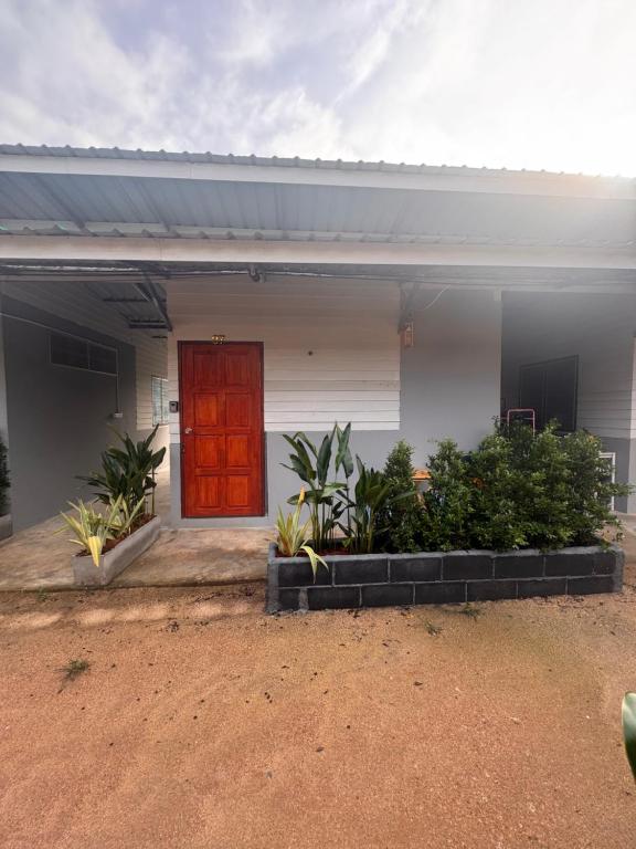 a house with a red door and some plants at Serenity House 4D in Ban Ko Khwan