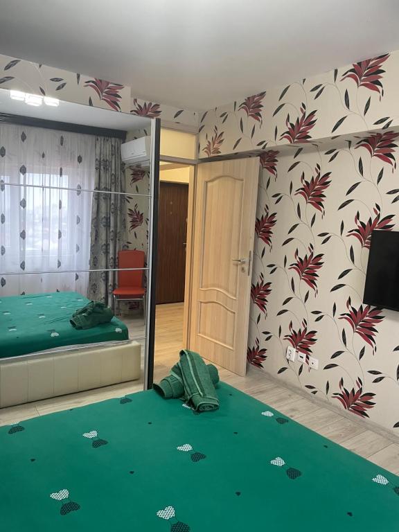 een kamer met een slaapkamer met een bed en een spiegel bij Apartament Central in Ploieşti