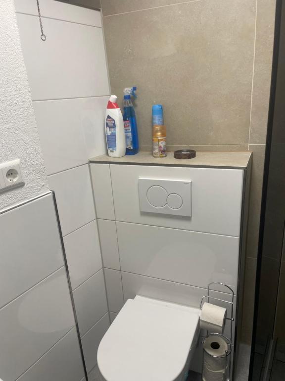 een kleine badkamer met een wit toilet en wat schoonmaakproducten bij Maisonette am Burg in Möckmühl
