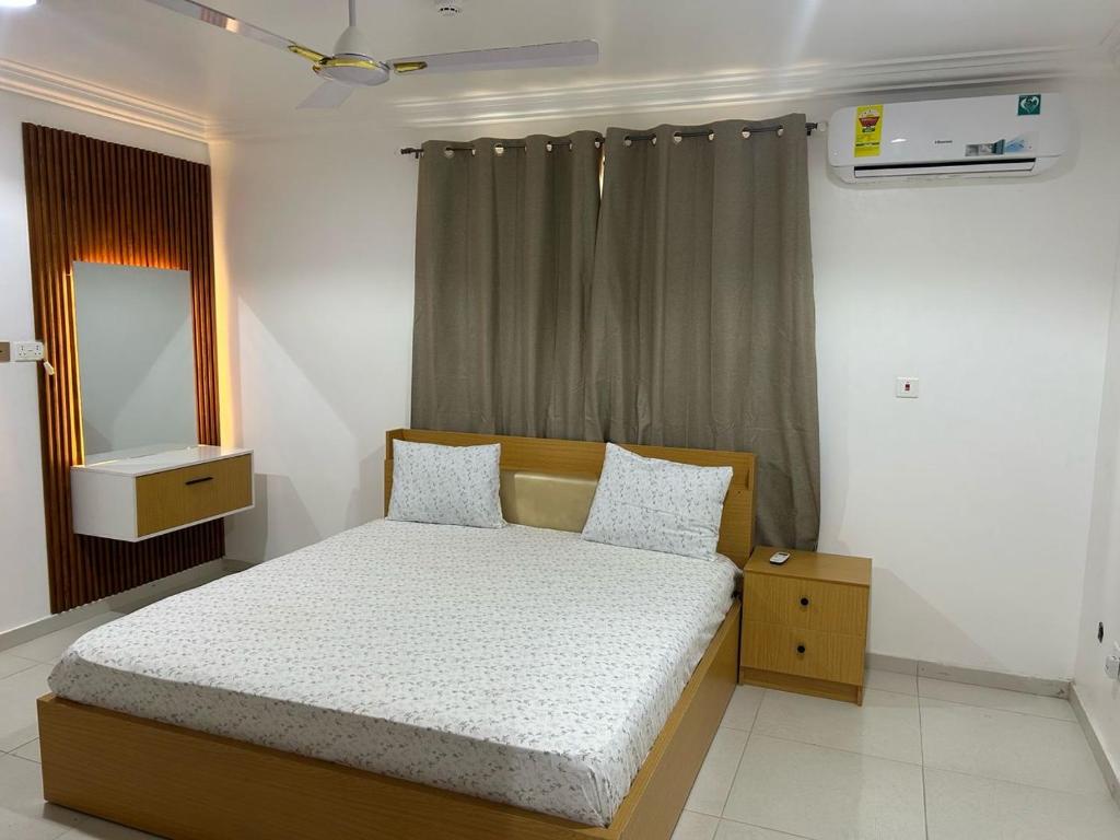 een kleine slaapkamer met een bed en een spiegel bij Mobile doctors apartment in Accra