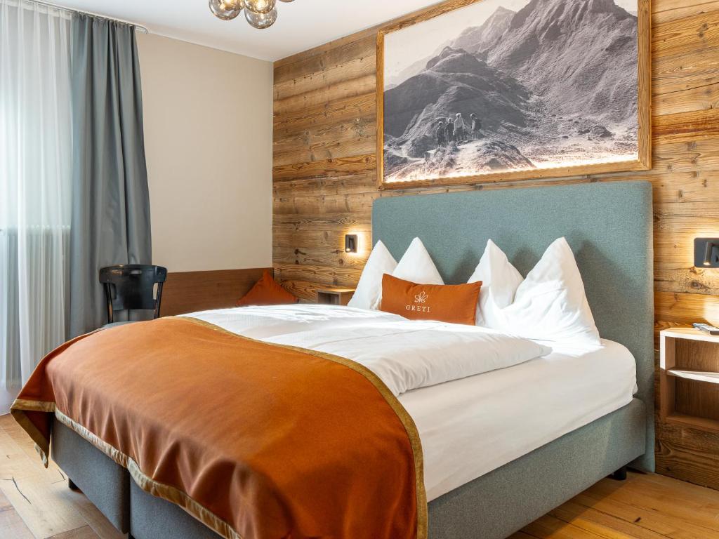 a bedroom with a large bed in a room at GRETI - Alpine Boutique Hotel mit Alpentherme Eintritt, reichhaltigem Frühstück, Sauna in Bad Hofgastein