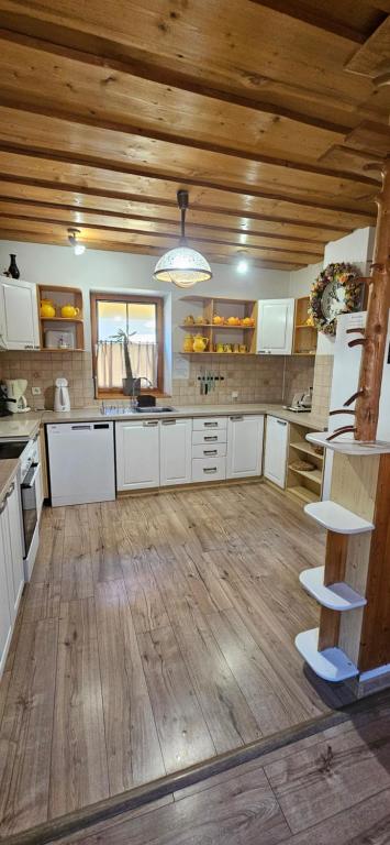 een grote keuken met witte kasten en een houten plafond bij Skiprivat in Ružomberok