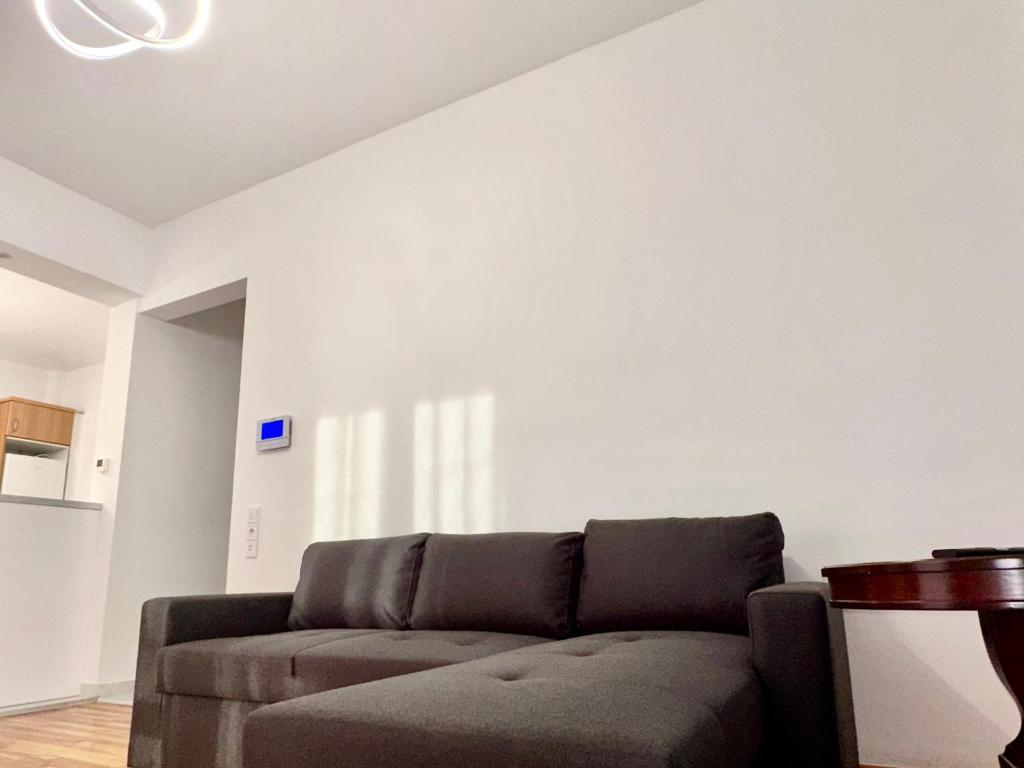 a living room with a couch and a white wall at VASKO Luxury Suites 3 in Siátista