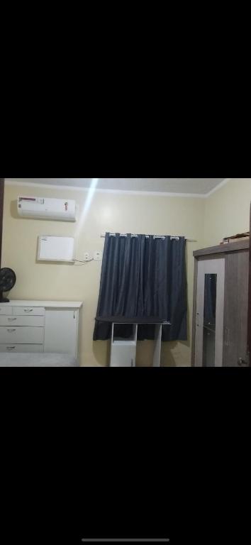 a bathroom with a blue curtain and a cabinet at Casa com 3 quarto mobiliada in Manaus