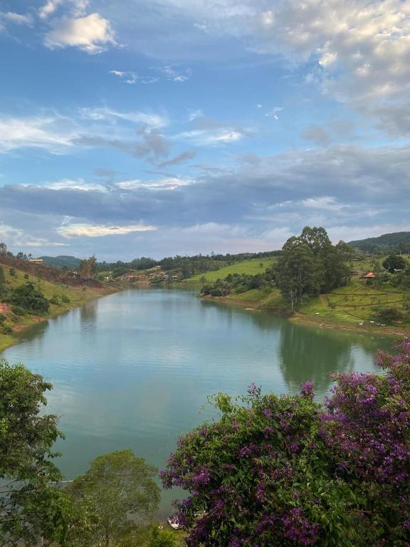 een uitzicht op een rivier met bomen en een hemel bij Chalé da lagoa in Paraibuna