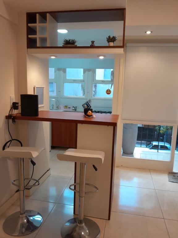 a kitchen with a counter and stools in a room at Vane Bravo in Mar del Plata