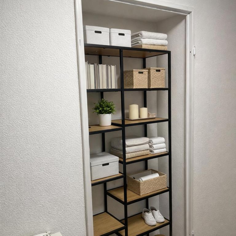 a book shelf with towels and boxes in a room at Maisonette am Burg in Möckmühl