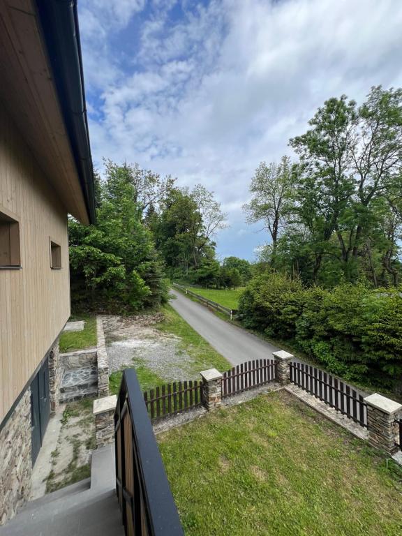 a house with a fence next to a road at Chalupa Bohunka in Kašperské Hory