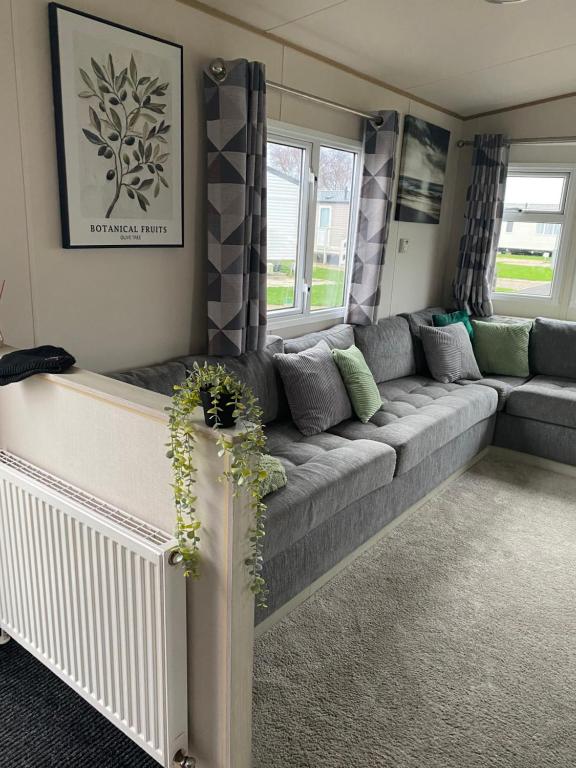 un soggiorno con divano grigio e finestre di SummerBreeze Retreat a Hartley