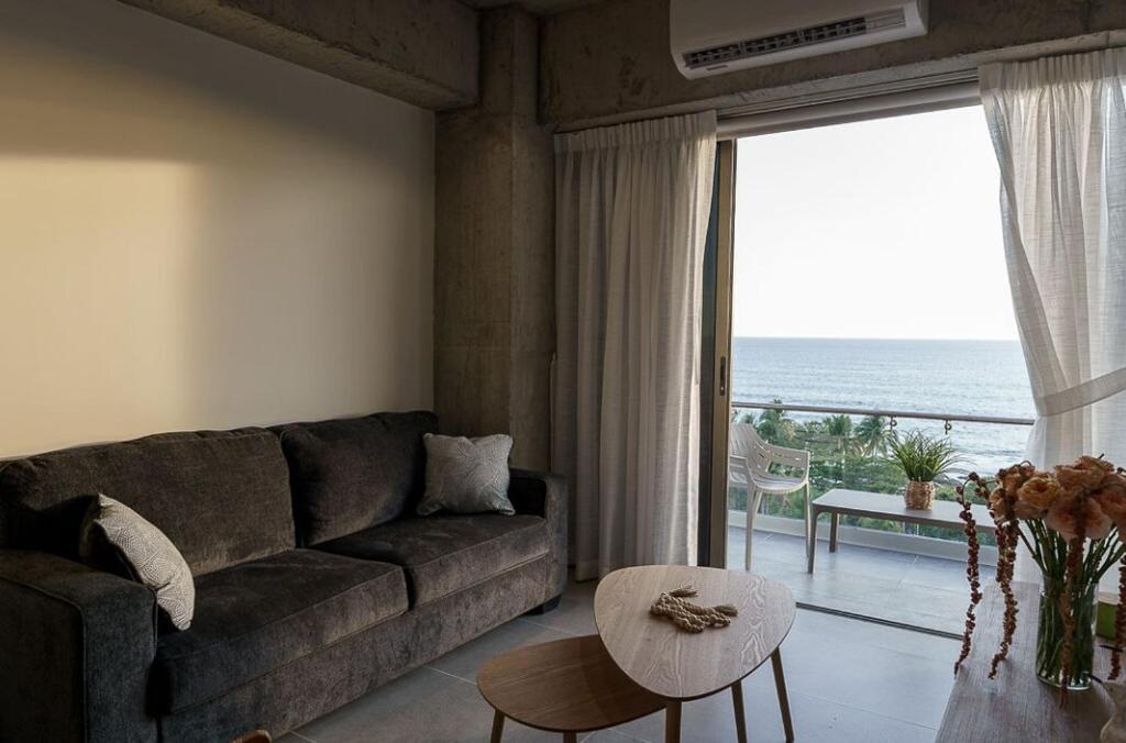 a living room with a couch and a view of the ocean at Spacious 2BR 2BTH El Zonte with oceanview and pool in El Zonte